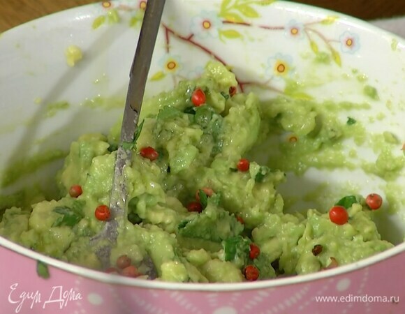 Приготовить гуакамоле: из лайма выжать сок, добавить мякоть авокадо и кинзу, все посолить, размять вилкой и посыпать розовым перцем.