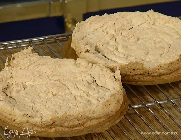 Дно разъемной формы выстелить бумагой для выпечки, бортики смазать сливочным маслом, равномерно выложить половину белково-ореховой массы и выпекать в разогретой до 150°С духовке 30 минут, затем так же выпечь второй корж. Готовые коржи полностью остудить.