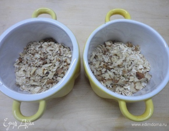 Овсяные хлопья разложить в горшочки. Добавить рубленые орехи (любые).