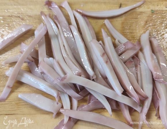Тушки кальмаров очистить и отварить. Разрезать на четвертинки, потом нарезать полосками.