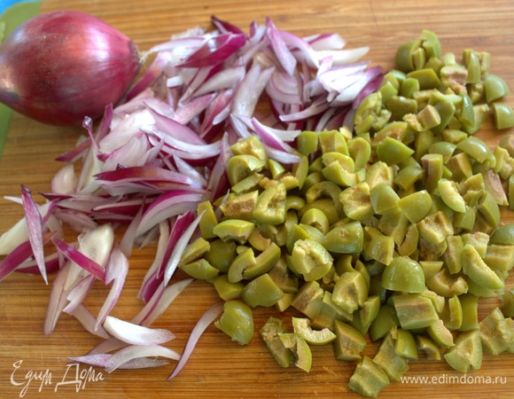 Лук тонко нарезать, оливки измельчить.