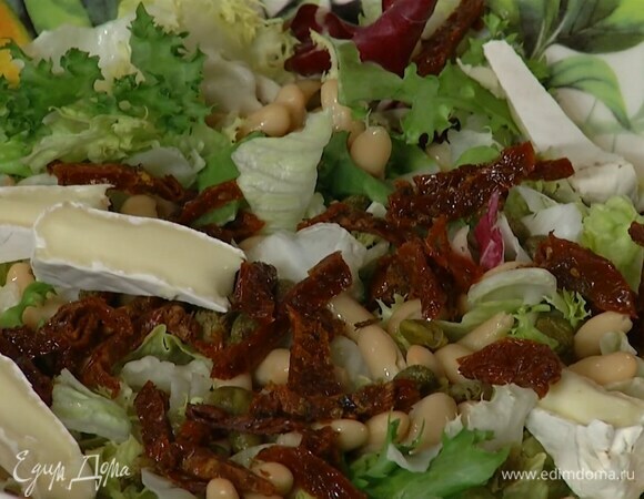 В глубокую миску выложить листья салата, отваренную фасоль и каперсы, добавить нарезанные вяленые томаты, сыр бри и порванные руками листья базилика.