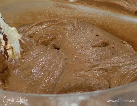 Яично-сливочную массу переложить в глубокую миску, добавить сметану, ванильный экстракт, всыпать муку с разрыхлителем и вымешать тесто лопаткой, затем влить растопленный шоколад и еще раз вымешать.