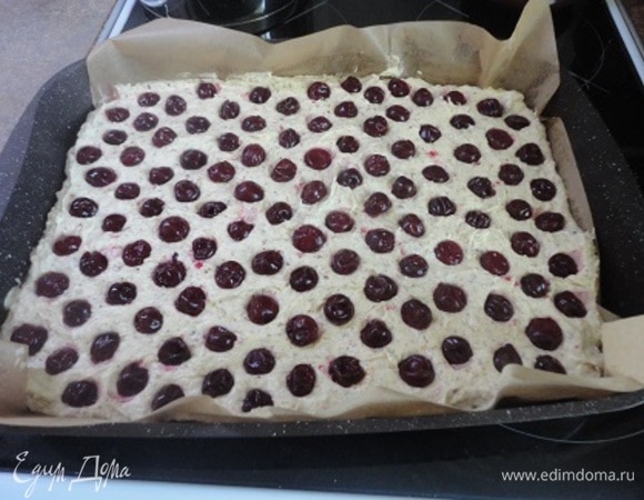 У меня противень размером 40 х 29 см. с хорошим антипригарным покрытием. Но я застелила его пекарской бумагой, чтобы удобнее было извлекать выпечку из формы. Можно взять форму немного меньшего размера, тогда бисквит будет толще. Равномерно распределить тесто на пергаменте. Выложить ягоды. У меня были замороженные, предварительно разморозила их. Но надо попробовать бы использовать ягоды не размораживая.