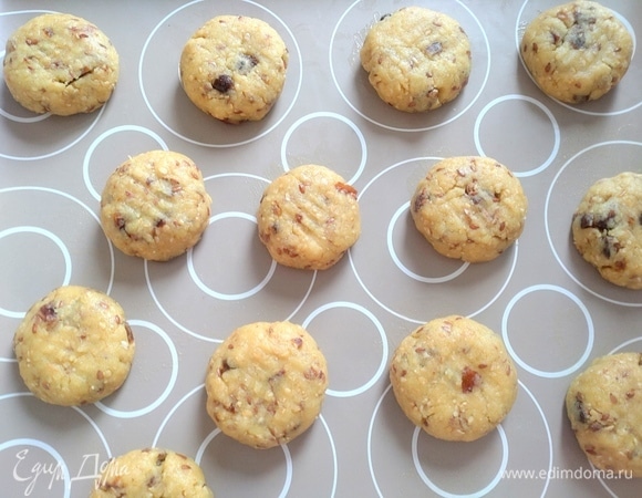 Скатать шарики из теста, приплюснуть на силиконовом коврике на противне.