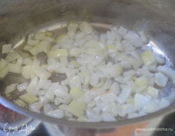 Лук нарезать мелкими кубиками, чеснок — пластинками. В кастрюле с толстым дном разогреть растительное масло и обжарить в нем лук до прозрачности, добавить чеснок.