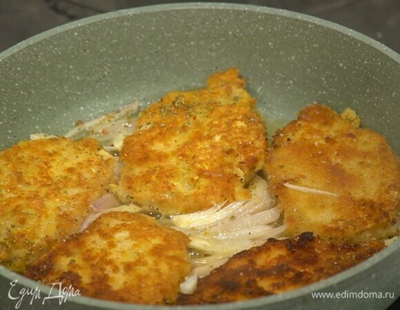 Посыпать эскалопы сухой петрушкой, перцем чили, влить вино и дать алкоголю выпариться, затем мясо еще немного посолить, накрыть сковороду крышкой и прогревать минут семь, до готовности.