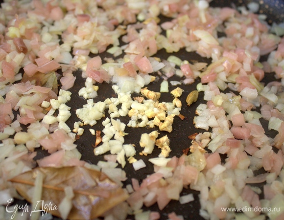 Пересыпать в сковороду вначале лук, позже чеснок. Подержать пару минут вместе.