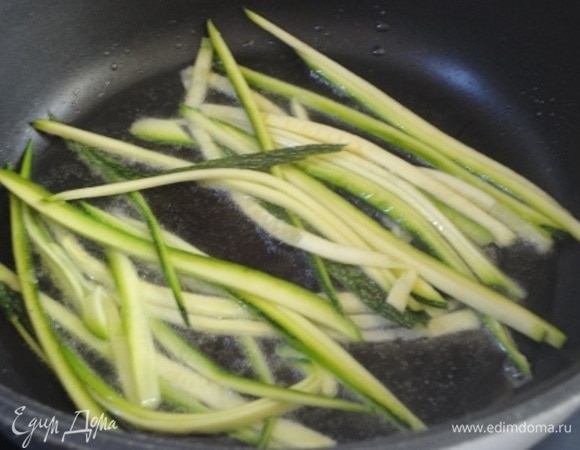 Цукини (или кабачки) нарезать в виде лапши и небольшими порциями быстро обжарить в горячем масле до желаемой консистенции. Посолить, поперчить.