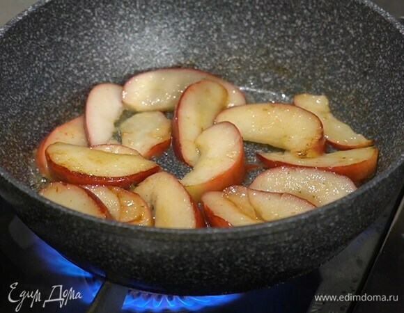 Разогреть в глубокой сковороде сливочное масло и потомить яблоки.