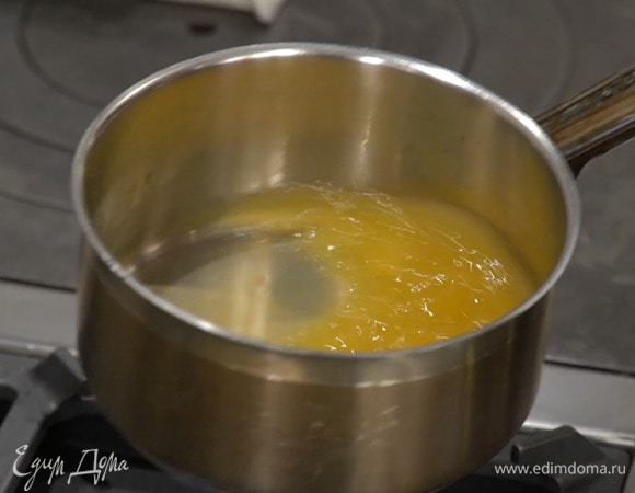 Приготовить пропитку: из апельсина и лимона выжать по 50 мл сока, влить в сотейник, добавить ликер, тростниковый сахар и сварить сироп, дав ему немного увариться.