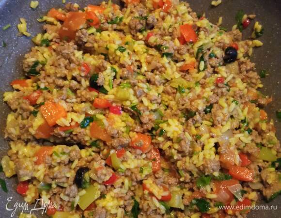 Отвариваем рис в подсоленной воде с добавлением порошка карри. Лучше отварить рис заранее, например с вечера. Этому я научилась в азиатской кухне. В таком случае рис не превратится в кашу. В сковороде разогреть кукурузное масло и обжарить мелко нарезанный лук 2 минуты. Выложить в сковороду с луком фарш и жарить минут 20.<br />
<br />
Добавить нарезанный некрупными кусочками сладкий перец, мелко порубленный чили, нарезанные колечками маслины и обжаривать еще минут 10. Добавить мелко нарубленную зелень петрушки и посолить по вкусу. В сковороду добавить вареный рис. Все перемешать и прогреть. При необходимости досолить.