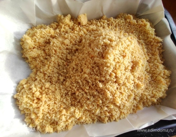 Форму 17 см на 22 см застелить пергаментом и высыпать масляную крошку.