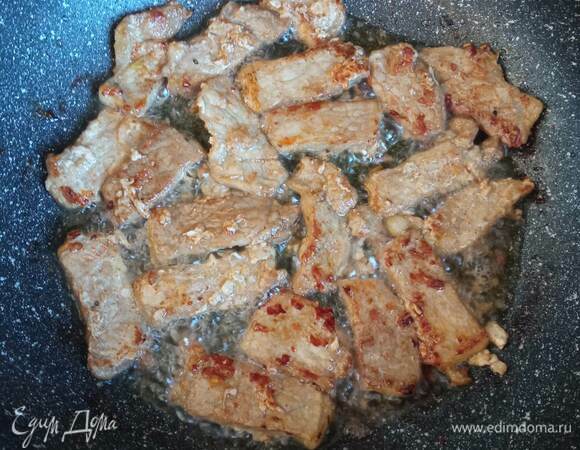 В сковороде разогреть растительное масло и обжарить в нем подготовленную свинину на сильном огне до румяной корочки.