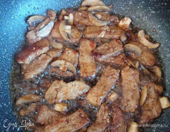 Смешать оставшееся количество соевого соуса, мед, томатный соус и лимонный сок. Залить соусом свинину, уменьшить огонь, накрыть крышкой и тушить минут 20–30 (в зависимости от толщины кусочков). Шампиньоны очистить и нарезать ломтиками, а после добавить к свинине. В процессе тушения проверить количество жидкости — при необходимости добавить немного горячей воды. Когда мясо готово, развести крахмал в половине стакана теплой воды и вылить в сковороду. Прогреть до загустения соуса, постоянно помешивая. 