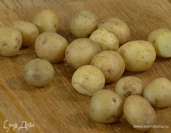 Мелкий картофель отварить до готовности в мундире, затем разрезать пополам.