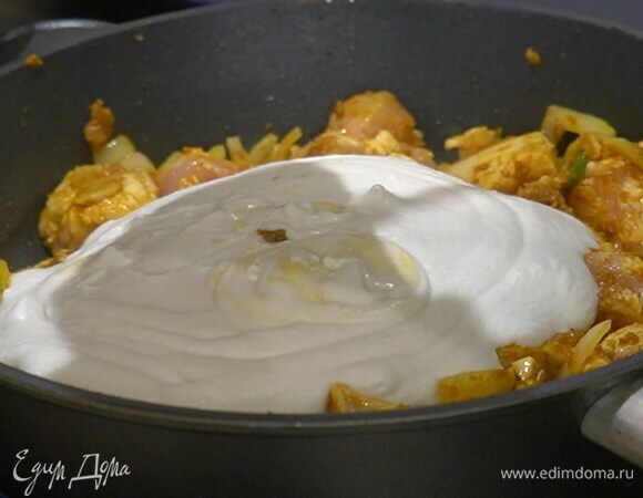 Влить кокосовое молоко, перемешать, уменьшить температуру и, не накрывая крышкой, томить курицу 10 минут без крышки, а затем еще несколько минут под крышкой.