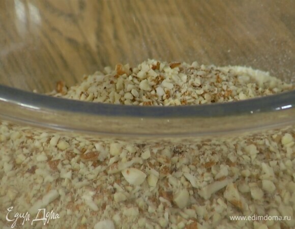 Миндаль подсушить в разогретой духовке, затем 75 г измельчить в муку, а оставшуюся часть порубить ножом.