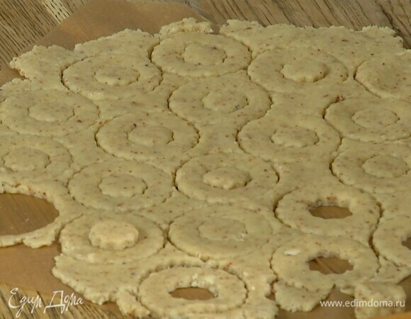 Кондитерскими формами вырезать из теста колечки и выложить их на противень, выстеленный бумагой для выпечки.