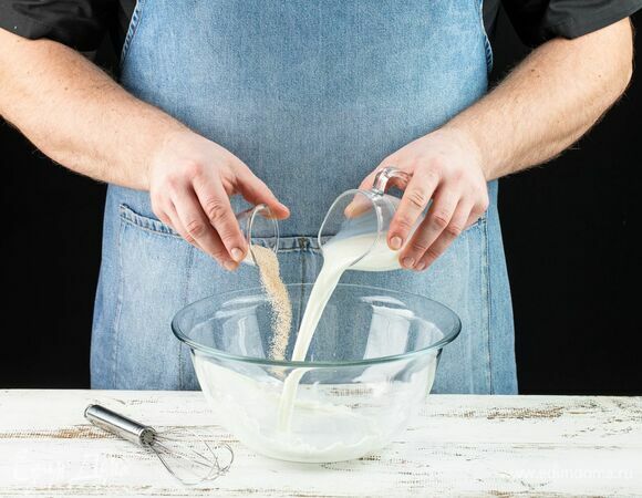 Сначала приготовьте опару для куличей. Для этого в глубокую емкость налейте теплое молоко, добавьте дрожжи.