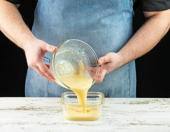 Перелейте глазурь в емкость так, чтобы слой глазури составлял 2–3 см. Накройте пищевой пленкой в контакт, иначе на поверхности образуется корочка. Уберите в холодильник для стабилизации на 6–8 часов.