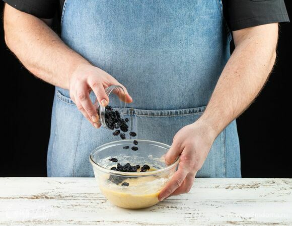 Добавьте изюм в тесто. Снова накройте тесто полотенцем и дайте постоять еще 1 час.