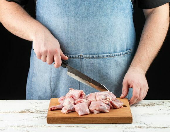 Нарежьте тушку кролика на порционные куски.