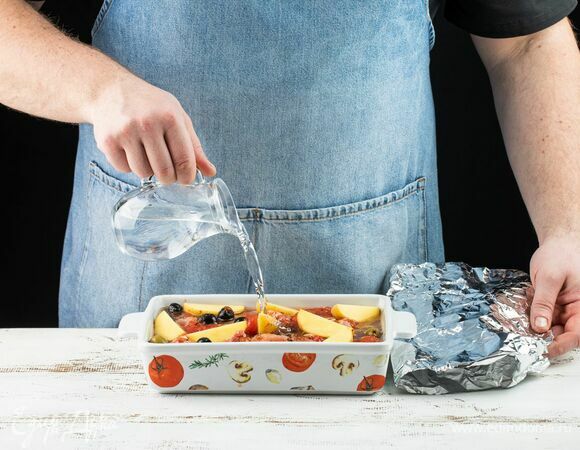 Влейте по краям немного воды. Накройте фольгой.