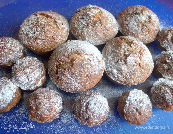 Вынуть кексы, остудить и посыпать пудрой.