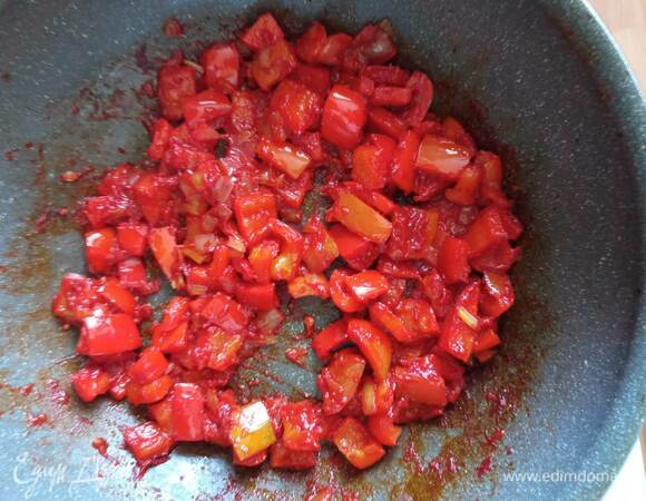 В этой же сковороде обжариваем мелко нашинкованный репчатый лук 2 минуты. Добавляем нарезанный некрупно болгарский перец. При необходимости добавляем растительное масло. Обжариваем 3–4 минуты, добавляем томатную пасту, обжариваем 1 минуту, добавляем немного воды или бульона (примерно 1 стакан). Даем закипеть.