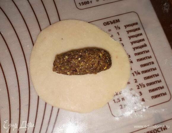 Положите в центр маленькую колбаску из орехов и защипните края.