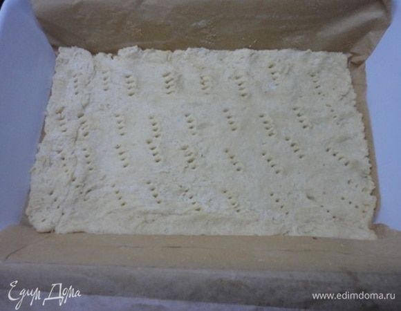 Для песочного теста в блендере перетереть муку, сахар, соль и разрыхлитель с кусочками холодного масла до консистенции не слишком мелкой крошки. Добавить остальные ингредиенты и собрать тесто в шар. Если масса суховатая и не собирается вместе, добавить несколько столовых ложек воды. Тесто разделить на 2 неравные части, 2/3 и 1/3, и завернуть каждую в пищевую пленку. Большую часть теста поместить в холодильник на 1 час, а меньшую — в морозильную камеру.<br />
<br />
По истечении указанного времени включить духовку для разогрева до 180°С. Достать большую часть теста из холодильника и тонко раскатать размером с дно формы для выпекания (примерно 18 х 30 см). Форму застелить пергаментом, так чтобы он прикрывал и стенки формы. На дно формы выложить раскатанное тесто. Проколоть тесто вилкой в нескольких местах. Убрать форму с тестом в холодильник.