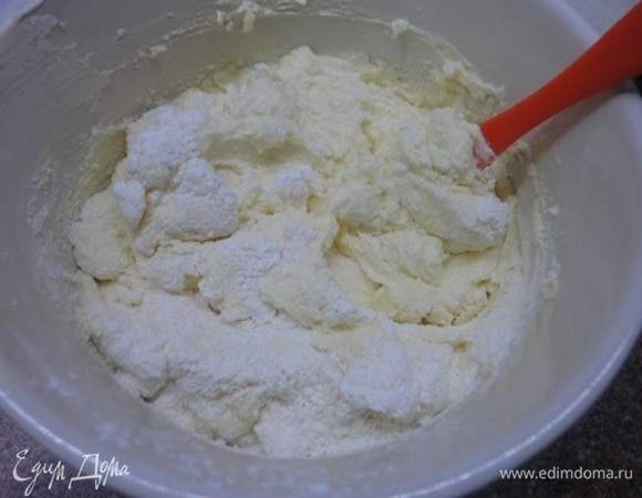 Для начинки творог пропустить через мясорубку 3 раза или пробить погружным блендером до однородной консистенции. Масло взбить с сахаром до кремовой консистенции. Продолжая взбивать, ввести по одному желтки. Затем порциями добавить протертый творог, продолжая взбивать. Крахмал смешать с манной крупой и добавить к творожной массе. Белки (5 шт.) взбить до образования стабильных пиков и порциями осторожно, но уверенно ввести в творожную массу. Выложить ее на подготовленное тесто.