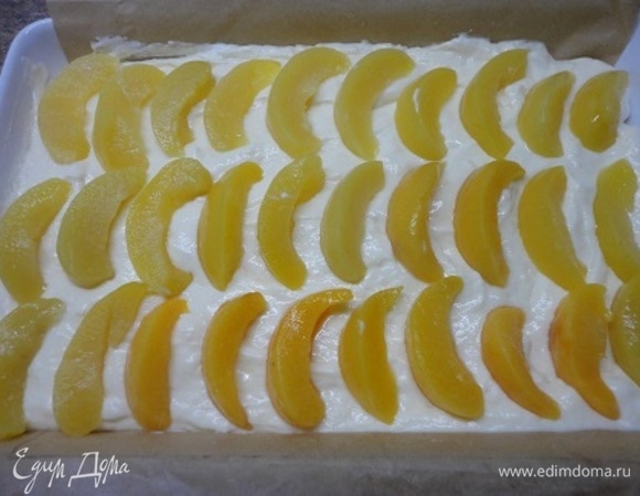 Персики откинуть на дуршлаг и дать стечь сиропу. Половинки персиков разрезать пополам и выложить на творожную массу.