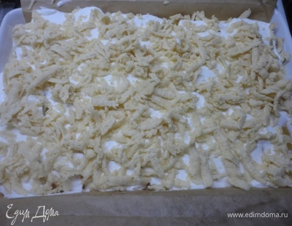 Достать из морозилки вторую часть теста и натереть на терке с крупными дырочками. Распределить тертое тесто по поверхности белков.