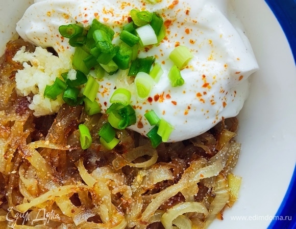 Выкладываем лук в глубокую миску, добавляем греческий йогурт, два зубчика чеснока через пресс, режем немного зеленого лука.