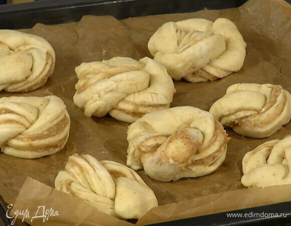 Булочки выложить на противень, выстеленный бумагой для выпечки, накрыть влажным полотенцем и отправить на расстойку в теплое место.
