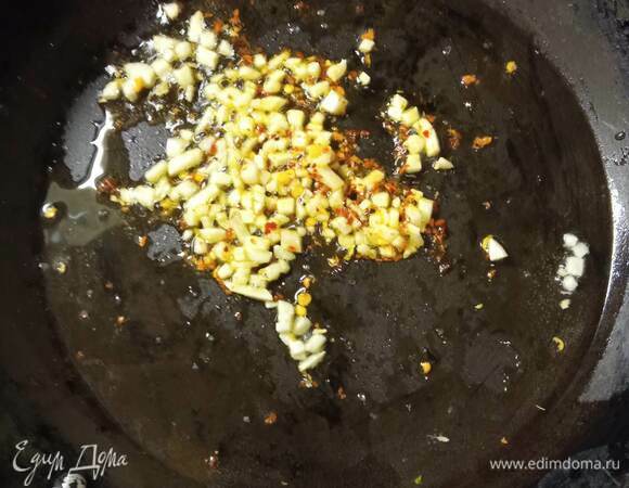 Отвариваем спагетти на 1 минуту меньше, чем указано на упаковке. В чашку отливаем воду из кастрюли, остальное сливаем. Креветки отвариваем в кипящей воде 4 минуты. В сковороде разогреваем растительное масло и обжариваем в нем мелко нарубленный чеснок и перец чили 1 минуту.