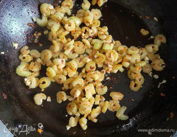 Пока варится фасоль с овощами, на сковороде обжариваем в масле перец чили 1 минуту. Добавляем оставшийся сельдерей и обжариваем 5 минут.