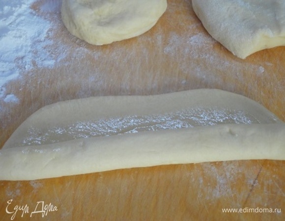 Тесто делим на равные части, примерно по 100 г. Каждую раскатываем в прямоугольный пласт, смазываем растительным маслом и сворачиваем рулетом по длинной стороне.