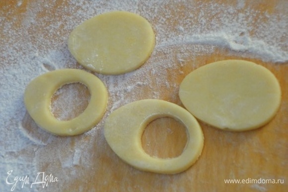 Теперь готовое охлажденное тесто раскатываем на посыпанной мукой поверхности и с помощью формочек вырезаем печенье: равное количество в виде цельного яйца и в виде яйца с отверстием.