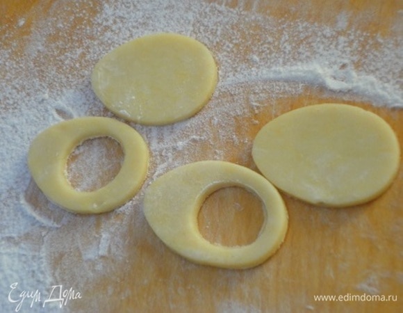 Теперь готовое охлажденное тесто раскатываем на посыпанной мукой поверхности и с помощью формочек вырезаем печенье: равное количество в виде цельного яйца и в виде яйца с отверстием.