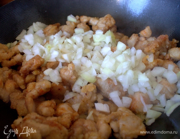 Пересыпать лук к курице, обжарить вместе.