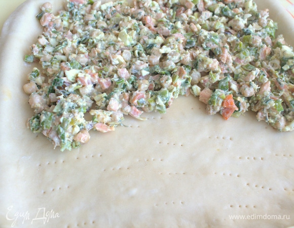 Часть побольше раскатать, перенести на противень с бортиками, наколоть дно вилкой.