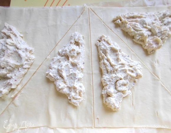 Нарезать тесто на треугольники, нанести начинку в центре каждого.