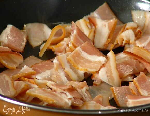 Бекон нарезать небольшими кусочками и обжарить на разогретой в мульти-кухне сковороде до золотистой корочки.