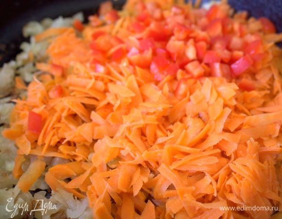 Добавить тертую морковь и нарезанный томат.