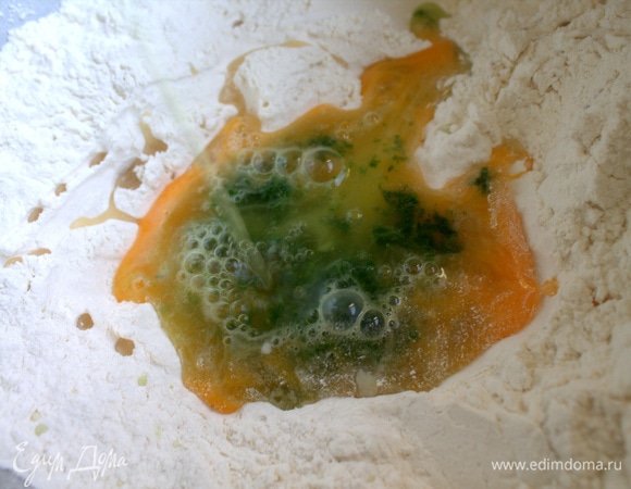 В муке сделать ямку, вбить яйцо, влить воду со шпинатом и растительным маслом.