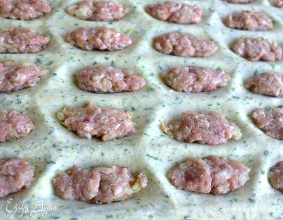 Отрезать часть теста и раскатать тонко по форме. В ямки положить примерно по 1 ч. л. фарша.