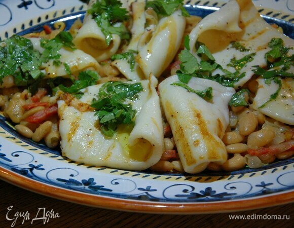 Выложить на блюдо фасоль и обжаренных кальмаров, а сверху зеленый соус.